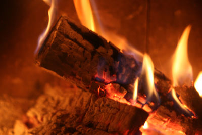 Ein Holzscheit liegt brennend im Kamin.