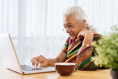 Eine indische Frau arbeitet an einem Laptop.