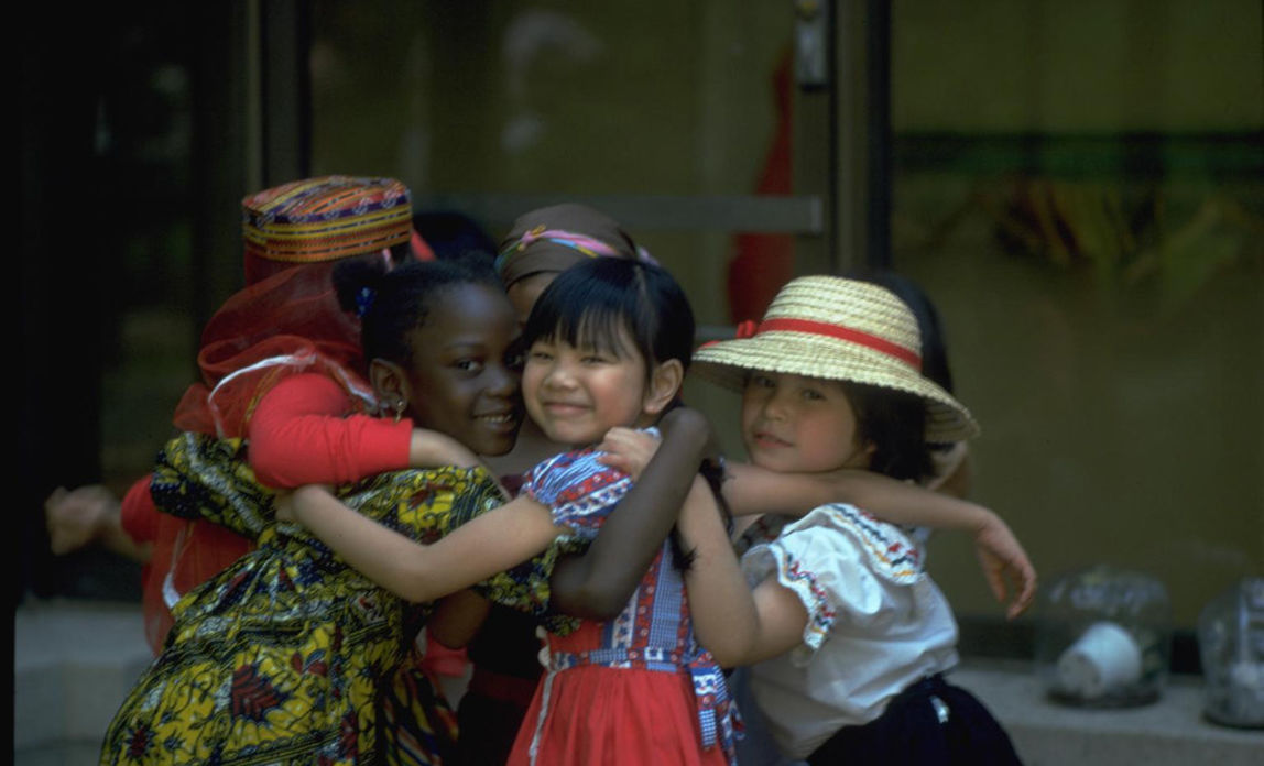 New York City 1979: Eine Gruppe von Mädchen in traditioneller Kleidung umarmt sich. © UNICEF/UNI39719/Rotner